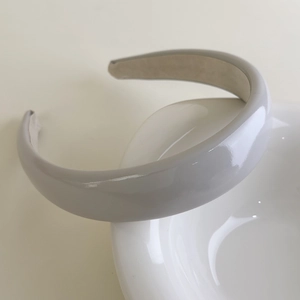 Detail of grey patent leather sponge headband showing glossy finish and non-slip lining