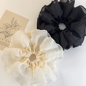 Close-up of black and cream oversized pleated chiffon hair scrunchies with soft texture
