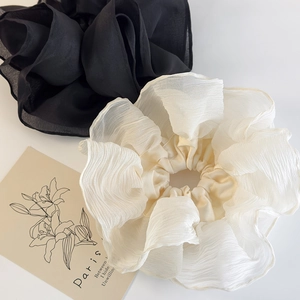 Detail of oversized lace scrunchies in black and beige organza fabric for ponytails