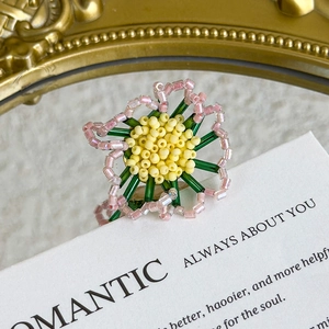 Detail of a handmade floral shoe charm featuring pink beads and a green stem