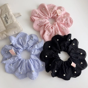 Vue détaillée de trois chouchous en dentelle rose, violet et noir avec perles