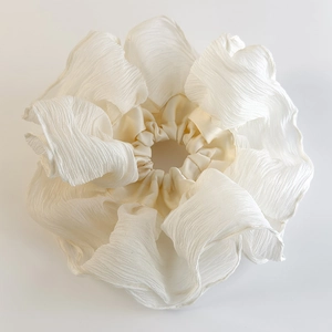 Detail of oversized cream white pleated scrunchie showing fine fabric texture and ruffles