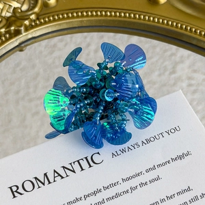 Macro shot of blue iridescent floral shoe charms with sparkling sequins for DIY decoration