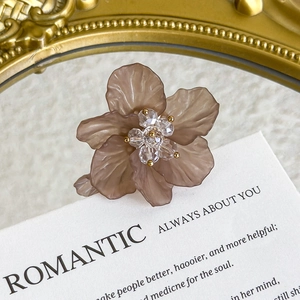 Detailed macro view of translucent brown flower charm with crystal and gold bead center