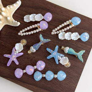 Barrettes sirène coquillage et étoile de mer avec perles sur fond bois de noyer