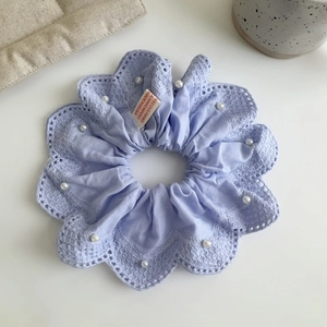 Vue détaillée du chouchou en dentelle lavande avec perles blanches et broderies