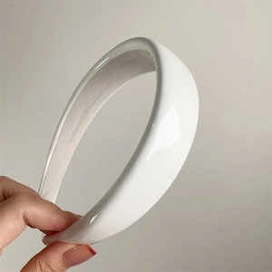 Detail of glossy white patent leather headband with non-slip grey inner lining