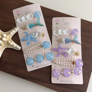 Détail de barrettes sirène avec perles et paillettes sur cartes de présentation