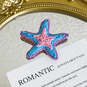 Macro detail of multilayered star-shaped shoe charms with unique woven texture and colors