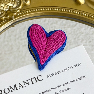 Macro shot of pink and blue woven heart-shaped shoe charms with detailed fiber texture