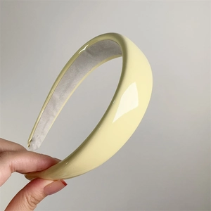 Detail of glossy patent leather yellow headband with soft padding and anti-slip lining