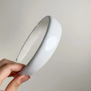 Detail view of white glossy patent leather headband with sponge padding for high crown