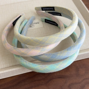 Detail view of handmade plaid headbands in pastel macaron colors with woven texture