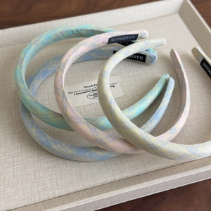 Pastel plaid thin headbands in macaron colors displayed in a textured tray