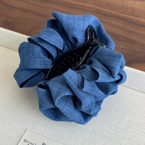 Detail of blue denim fabric hair claw clip with pleated texture and vintage French style