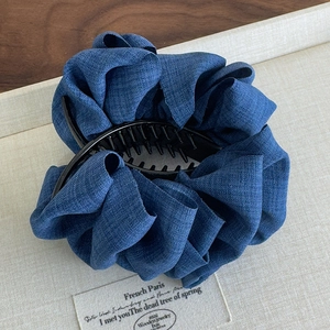 Detailed view of denim fabric ruffles on a large hair claw clip for thick hair styling
