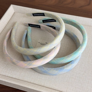 Detailed macro view of handmade plaid fabric headbands in assorted macaron pastel colors