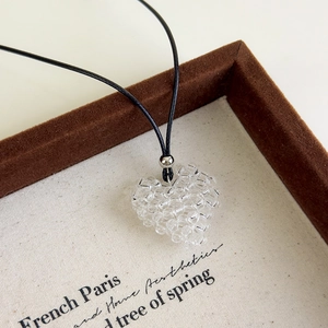 Vue détaillée du pendentif coeur perlé à la main avec un cordon noir réglable