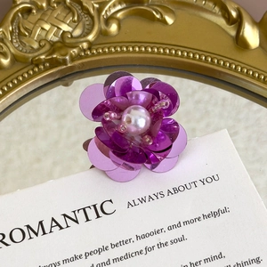 Detailed macro shot of purple sequin flower shoe charm with a pink faux pearl center