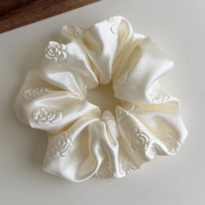 Dettaglio di un elastico in raso crema con trama a rose in rilievo 3D elegante