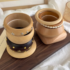 Vintage geometric wooden bracelets set with metal star rivets and beads on a tray