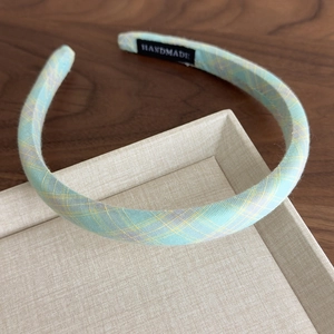 Detail of handmade mint green plaid headband with white HANDMADE label inside