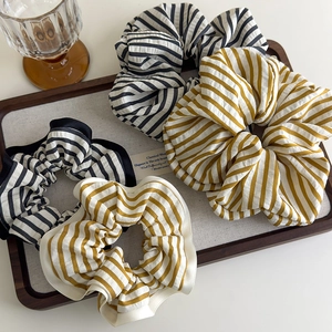 Chic striped fabric scrunchies set in black, white, and ginger yellow for low ponytails