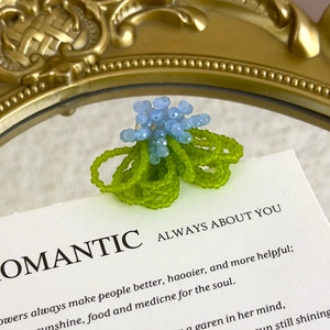 Detailed macro view of handmade crystal bead flower shoe buckle with blue and green charms