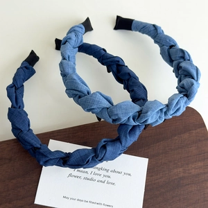 Détail de serre-têtes tressés en denim bleu aux teintes foncées et claires