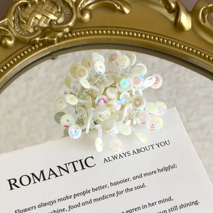 Detailed macro view of white iridescent floral charms and pearlescent beads for DIY shoes