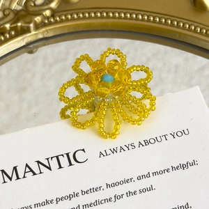 Macro shot of handcrafted yellow bead flower charm with light blue center for DIY shoes