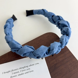 Détail du serre-tête tressé en denim bleu avec dents antidérapantes pour un maintien sûr