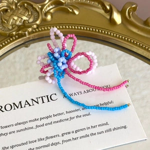 Detailed close-up of handmade beaded floral shoe charms with elegant long beaded tassels