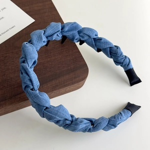 Détail d'un serre-tête tressé en denim bleu avec dents antidérapantes et texture tissu