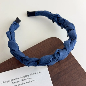 Détail du serre-tête tressé bleu denim avec dents internes et texture de tissu