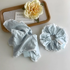 Light blue scrunchie and lace hair scarf set with a handmade tag on a white background