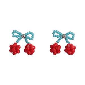 Handmade beaded cherry earrings with blue bow and red fruit clusters on white backdrop