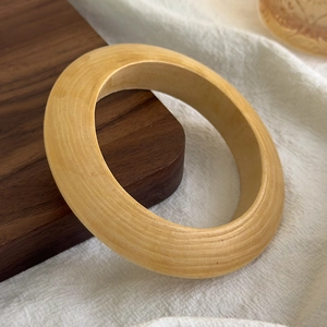 Detailed macro view of the natural wood grain and polished texture of this stylish bangle
