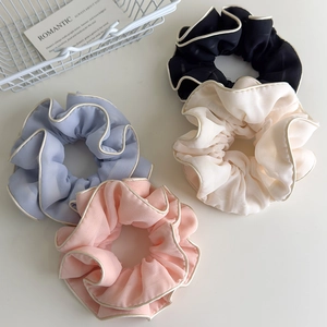 Elegant fabric scrunchies in four colors with ruffled edges and white trim design