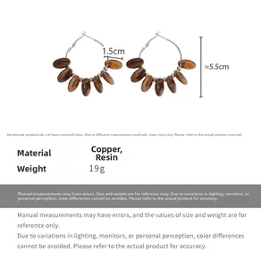 Detail view of large copper hoop earrings with brown marble-textured resin pendants