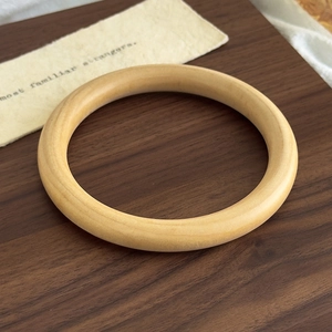 Macro detail of geometric natural wood bracelet with smooth polished grain and texture