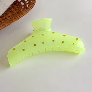 Detalle de pinza para el pelo amarillo neón translúcida con piedras brillantes