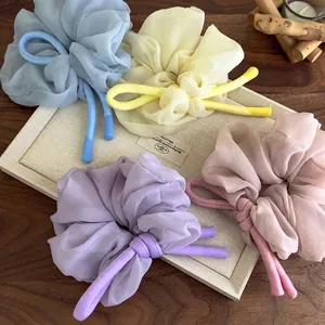 Chiffon scrunchies with bow knot in pastel Morandi colors on a minimalist wooden tray