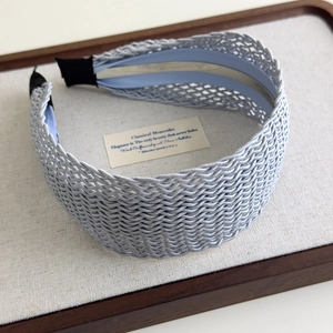 Macro detail of Bohemian woven wide headband with intricate texture in light blue silk finish