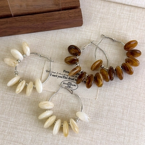 Bohemian style acrylic beaded hoop earrings with amber brown and cream marble texture