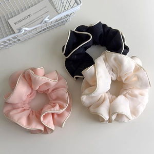 Three-piece set of large organza scrunchies in pink, black, and beige with golden piping