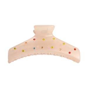 Pinza de pelo rosa gelatina con pedrería de colores sobre fondo blanco liso