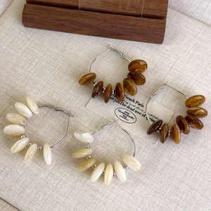 Detail of vintage French amber and cream marbled resin bead hoop earrings on fabric