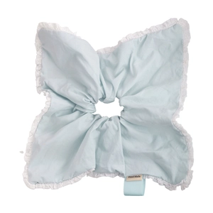Macro view of light blue scrunchie with white lace edges and Hand Made woven label