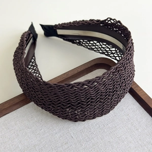 Detailed macro view of dark brown woven mesh headband with exquisite hollow patterns